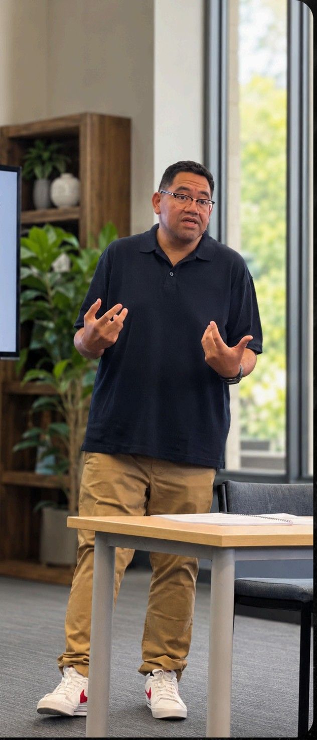 Dr Michael Fusi Ligaliga speaking at a desk during a workshop
