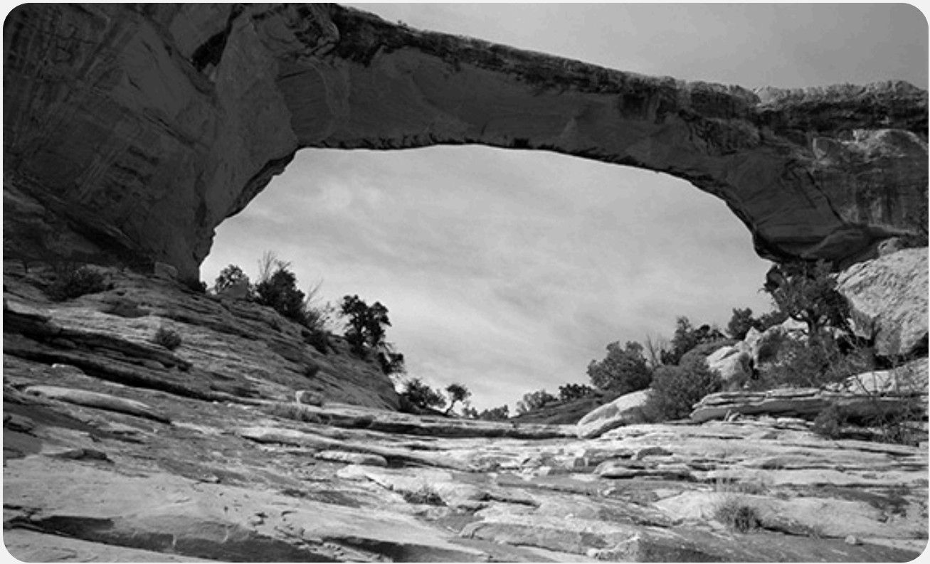 A natural stone arch in a desert landscape